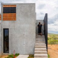 Concrete home with person standing on stairs