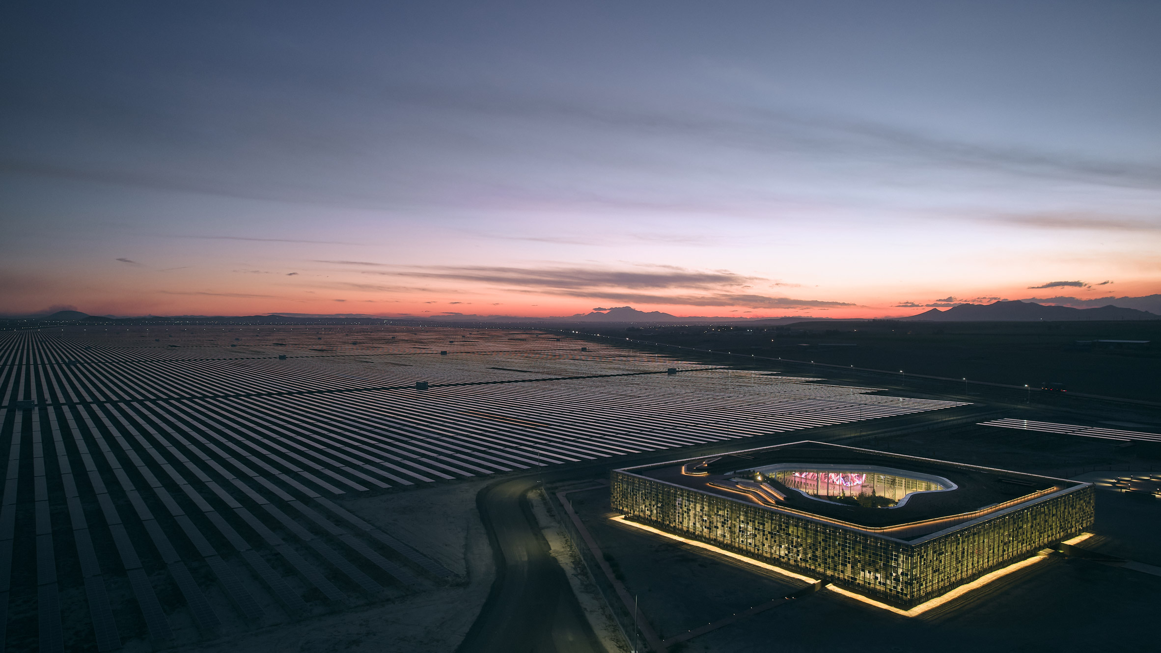 Night view of Central Control Building by Bilgin Architects amongst solar farm