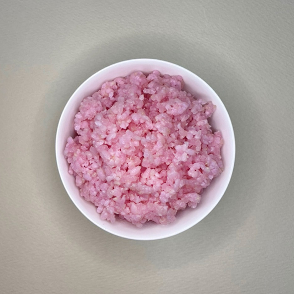 Photo of a bowl of pink-coloured rice viewed from above