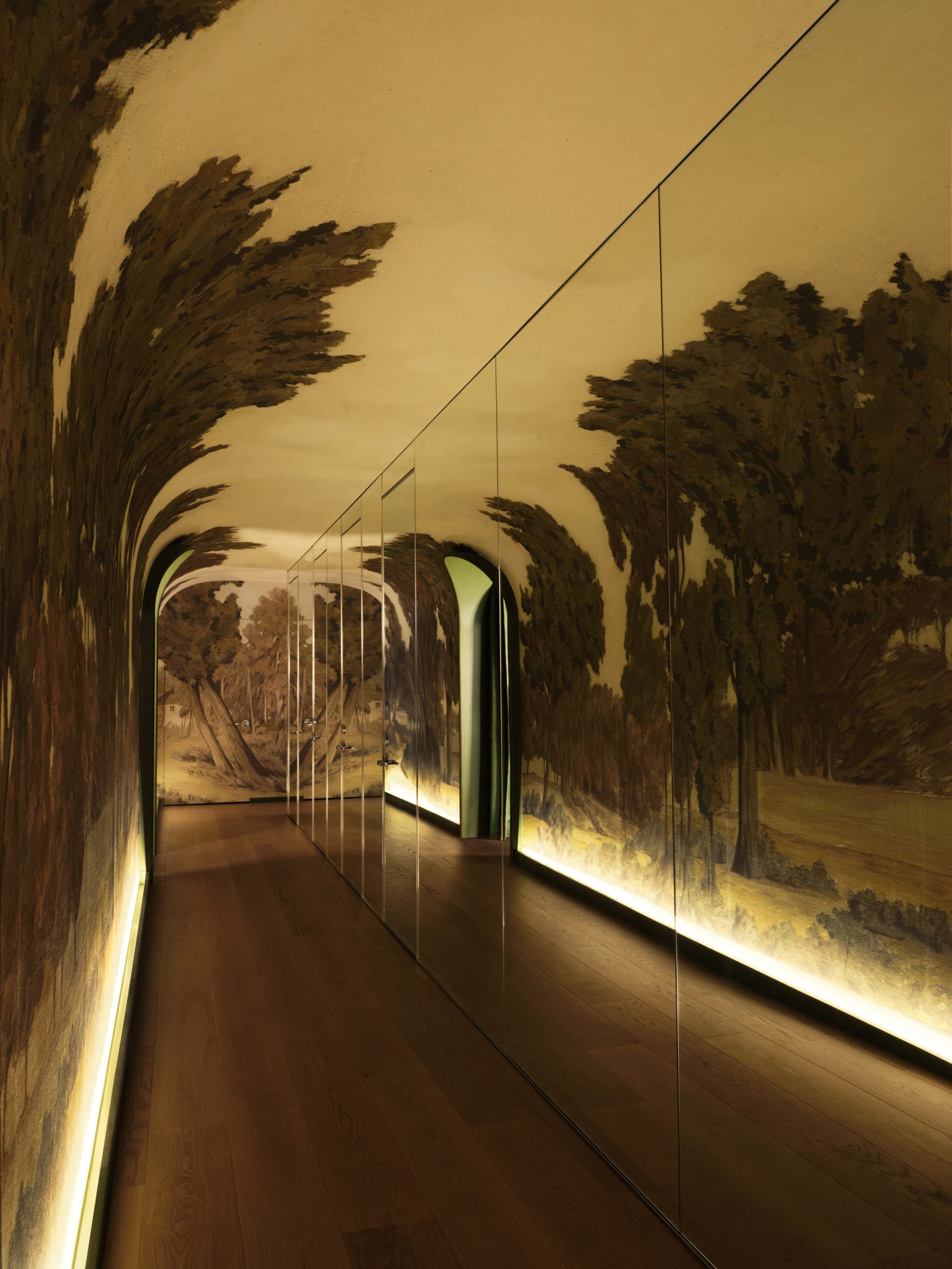 A mirrored corridor with a hand-painted landscape mural