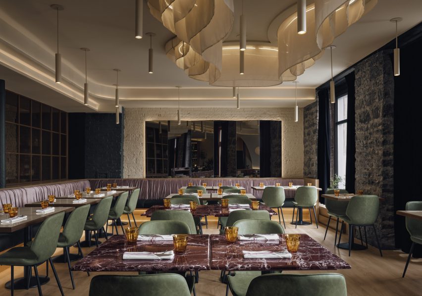 Phòng ăn với bàn đá cẩm thạch, ghế màu xanh lá cây và tường màu kem