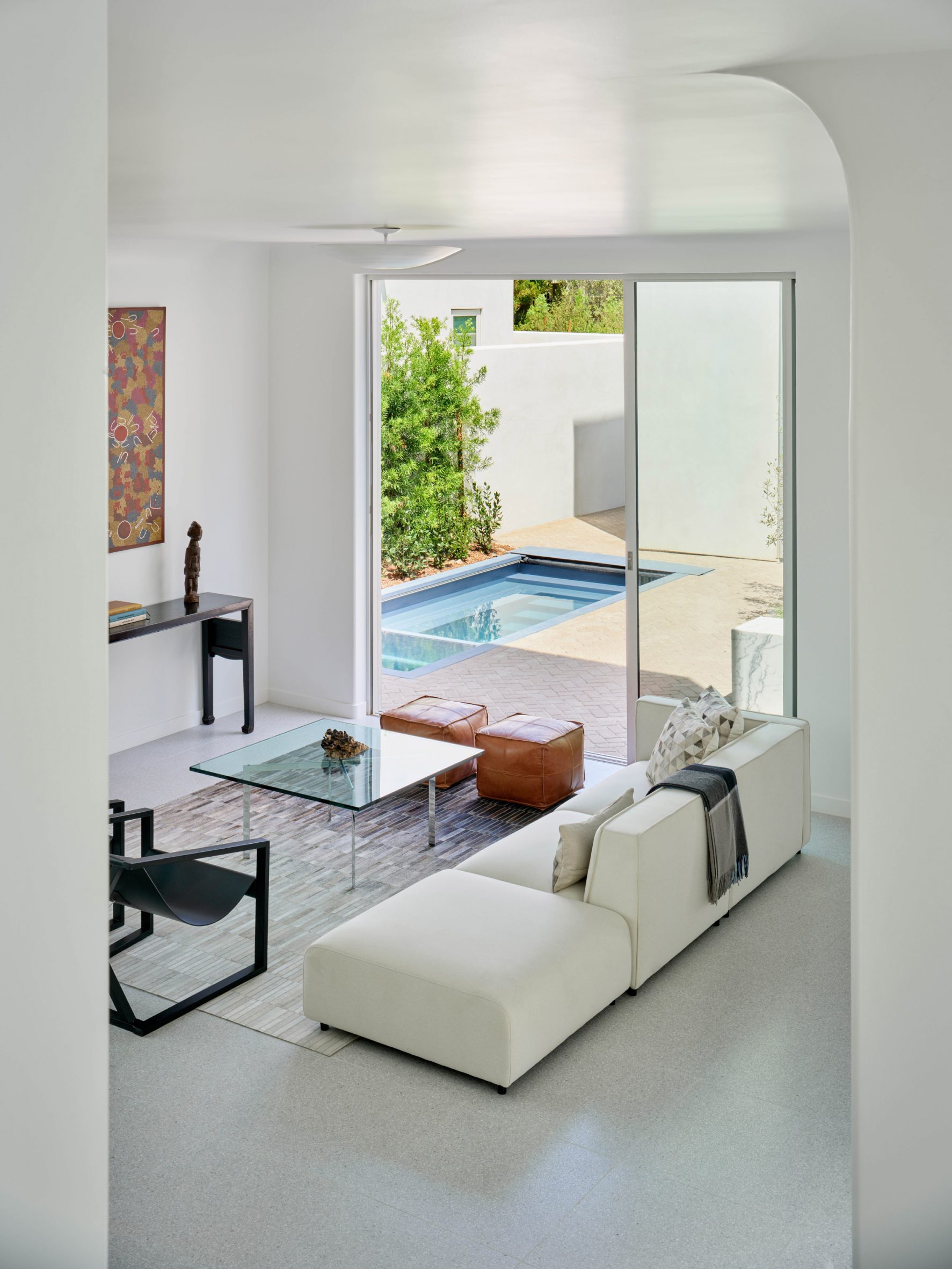 Living room with pool seen through courtyard doors