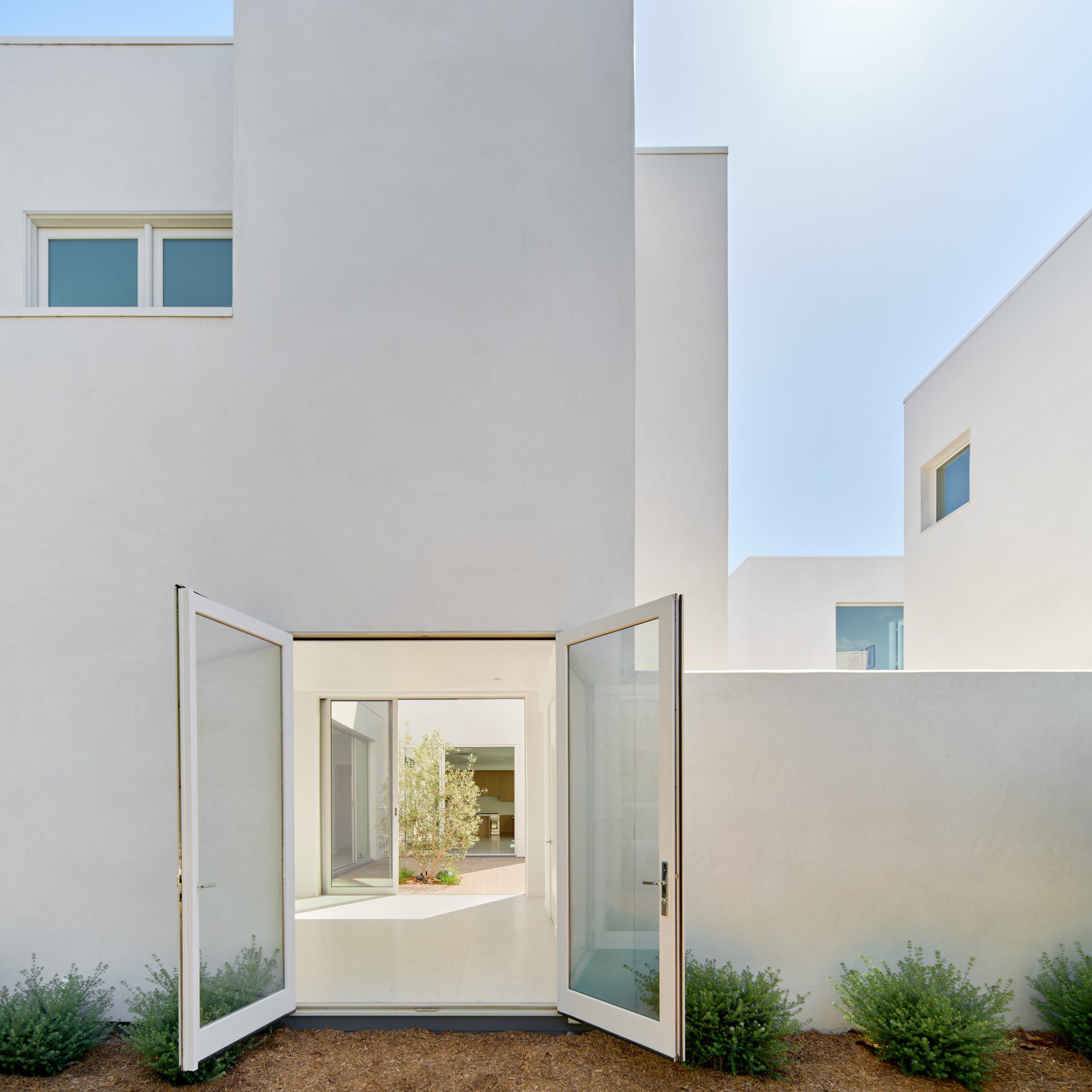 White stucco home with open door
