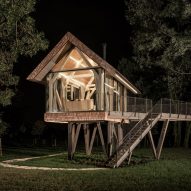 Exterior of glass micro house at night by Jan Tyrpekl in Austria