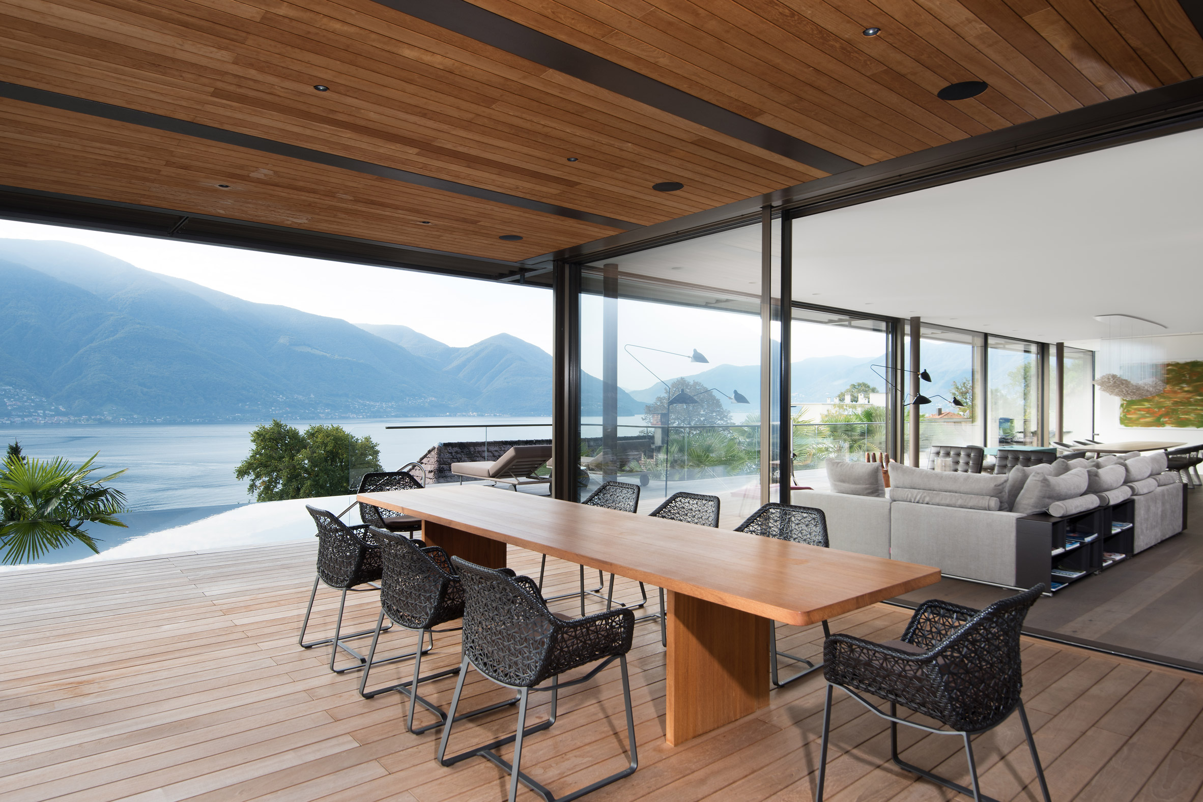 Covered outdoor dining terrace inside a cantilevered house by Küchel Architects in Switzerland