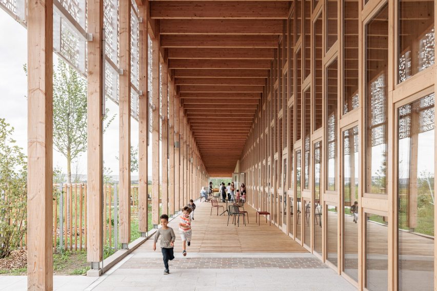 Sheltered walkway of timber-framed library by Atelier WOA
