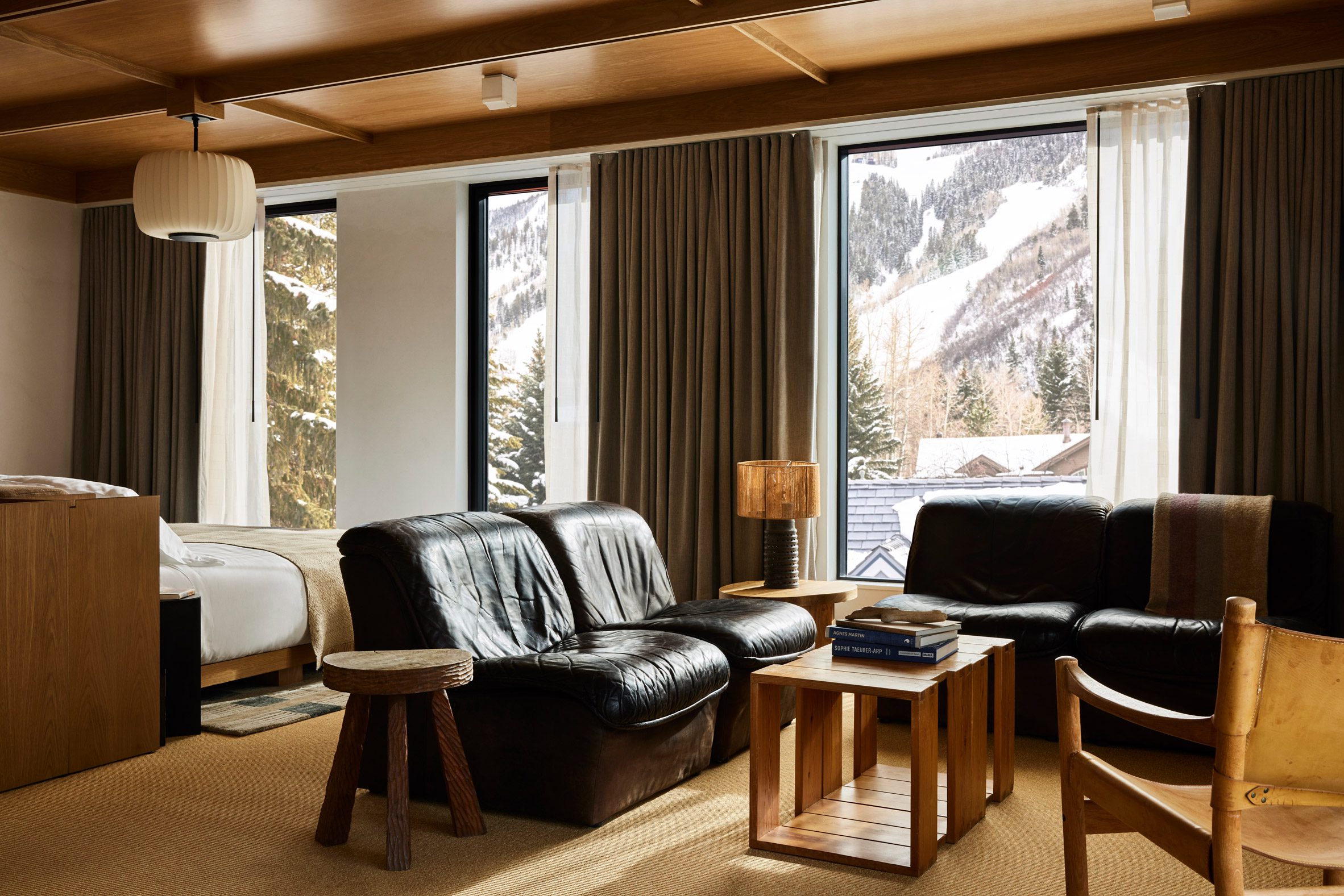 Guest suite with black leather furniture and snowy mountain views