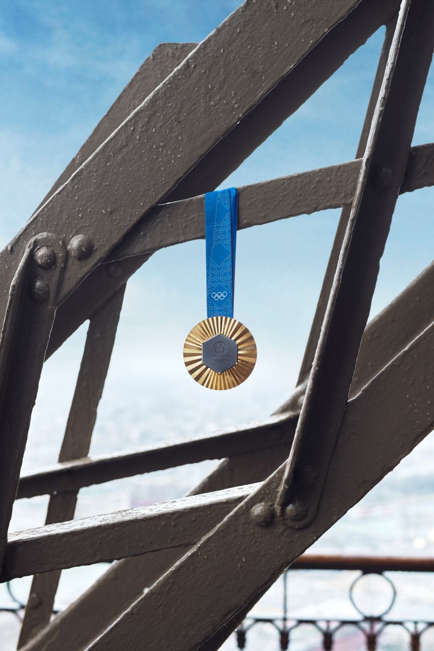 Gold 2024 Paris Olympic medal hanging from the Eiffel Tower