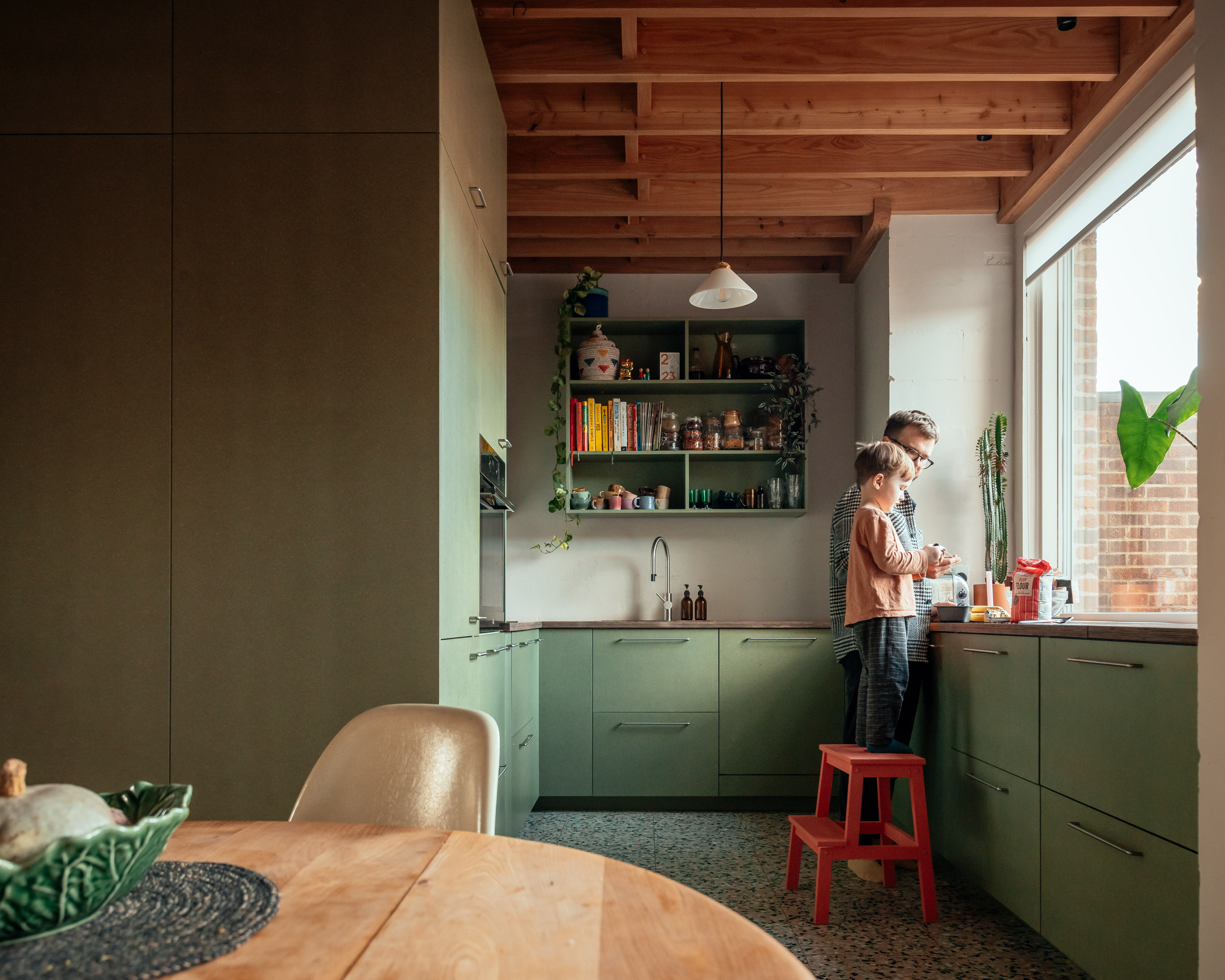 Kitchen with green cabinetry and timber roof