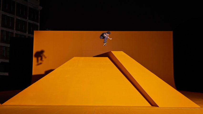 Yellow neon skate ramp with skateboarder mid air