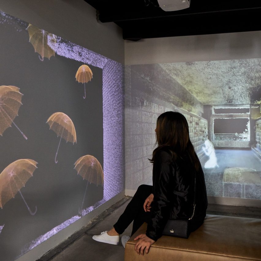 a photograph of a person looking at a projection on a wall
