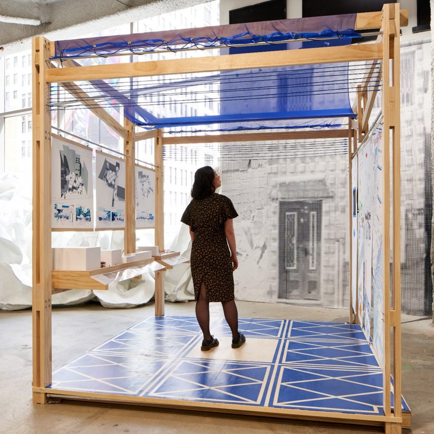 a photograph of a person standing within a square wooden structure