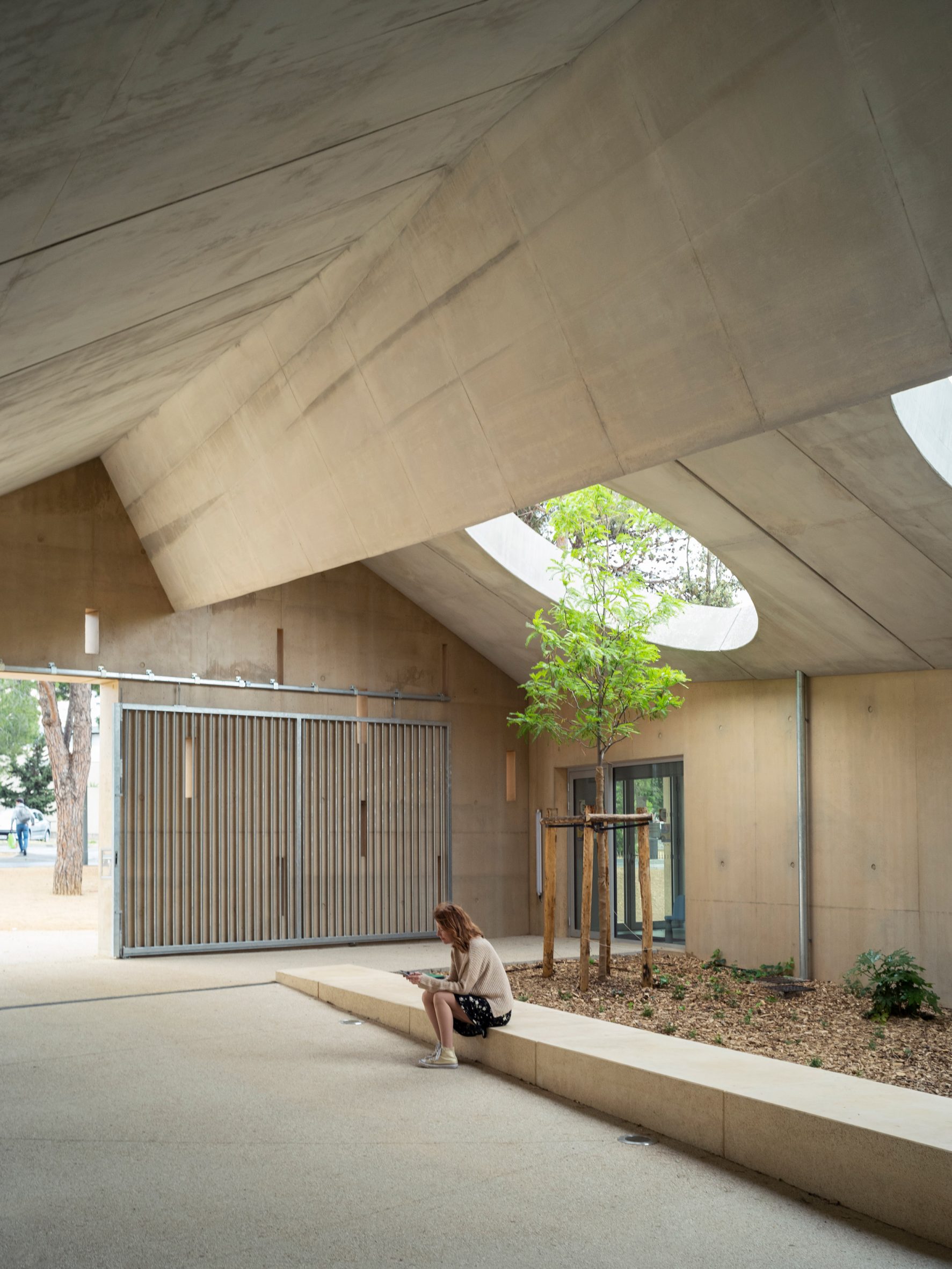 Sheltered entrance of school by Ateliers O-S and NAS Architecture