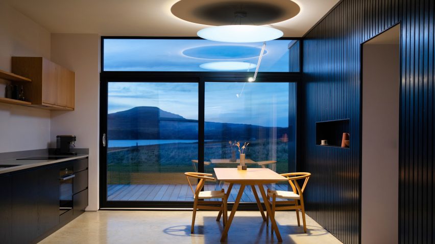 The Sunday Light daylight-mimicking lighting fixture suspended in a kitchen and dining room