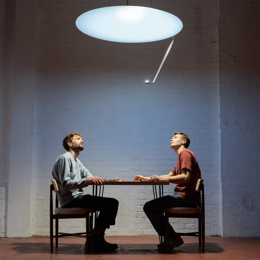 Zdjęcie Nata Martina i Seana Hammetta siedzących pod jasną okrągłą lampą