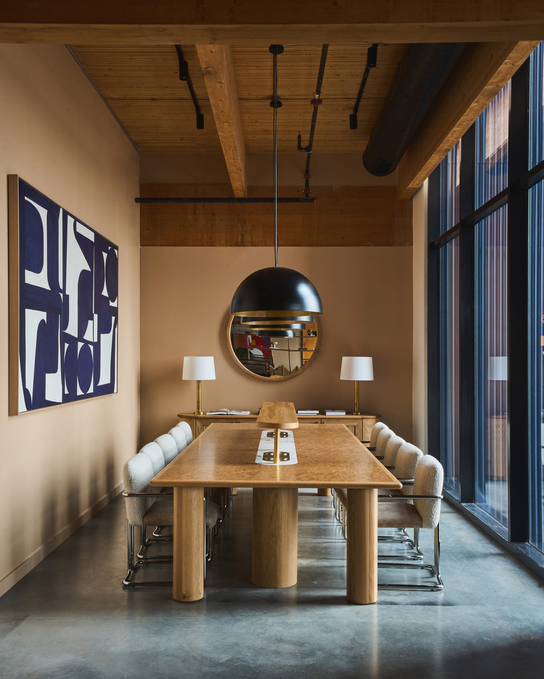 Meeting room with tan walls, large wooden table and tubular metal chairs