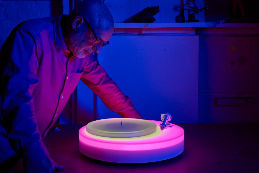 Brian Eno looking at light-up record player