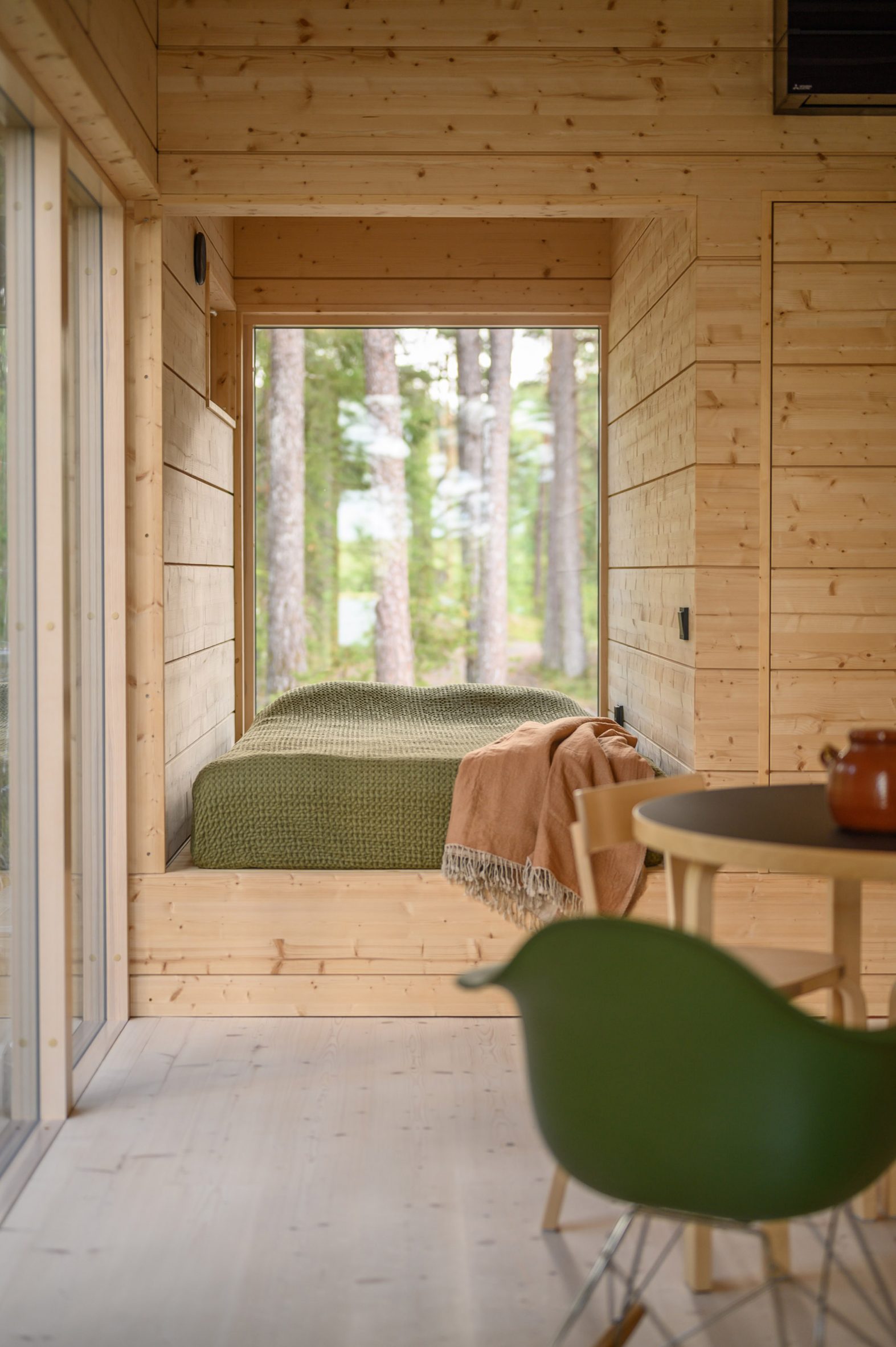 Bedroom interior within timber holiday home in Finland by MNY Arkitekter
