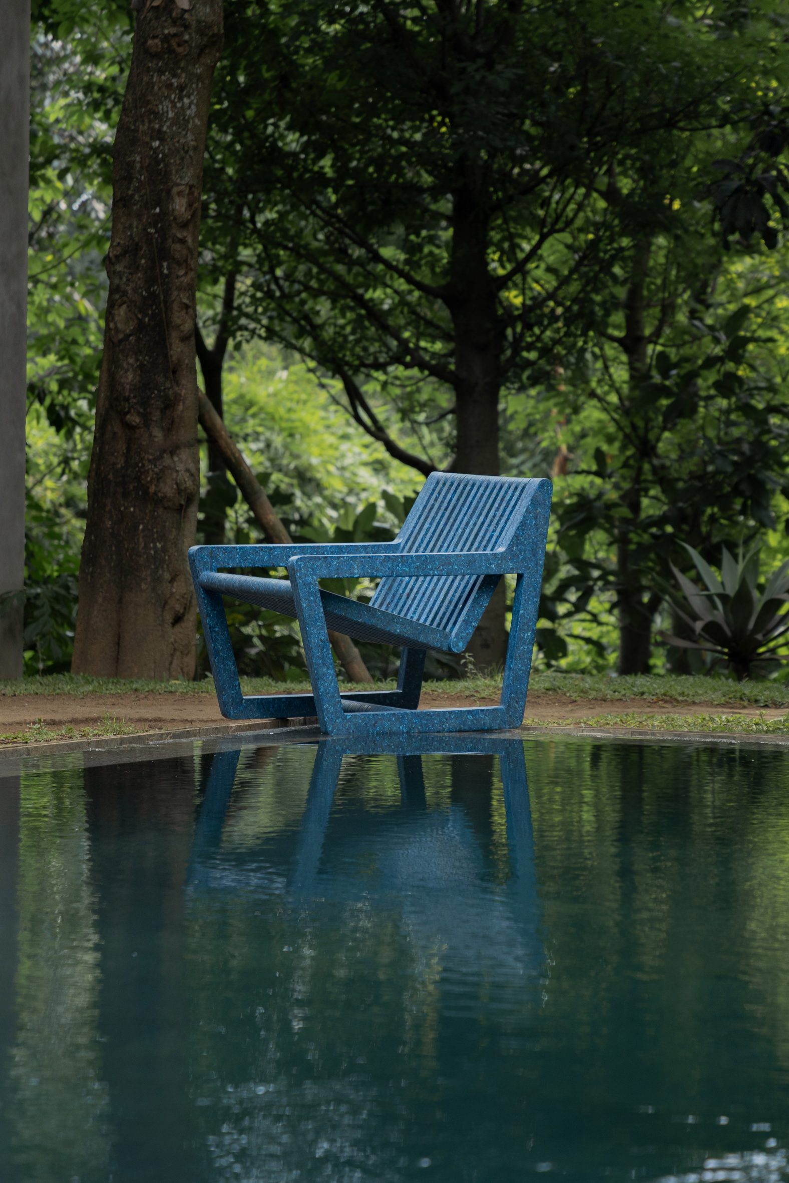 Blue Ombak chair next to a pool