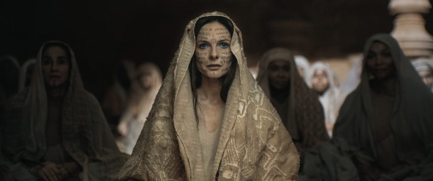 Dune Part Two production photos showing Lady Jessica after her transformation into a Reverend Mother of the Bene Gesserit Sisterhood, with glyphs on her body and followers sitting behind her