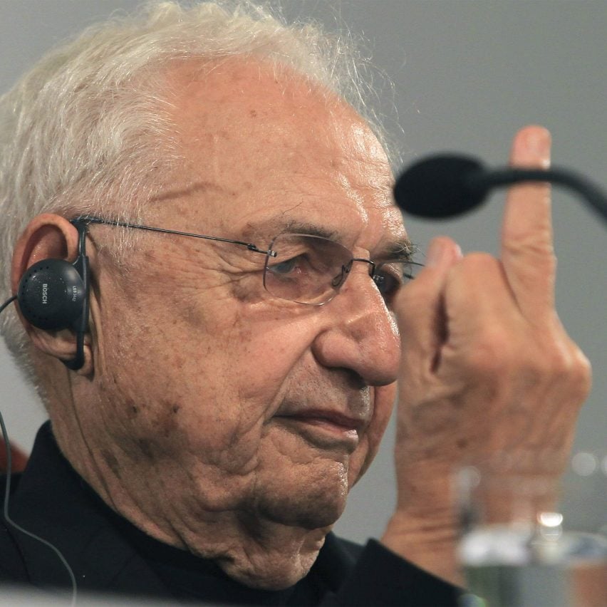 Frank Gehry holding up his middle finger at a press conference in 2014