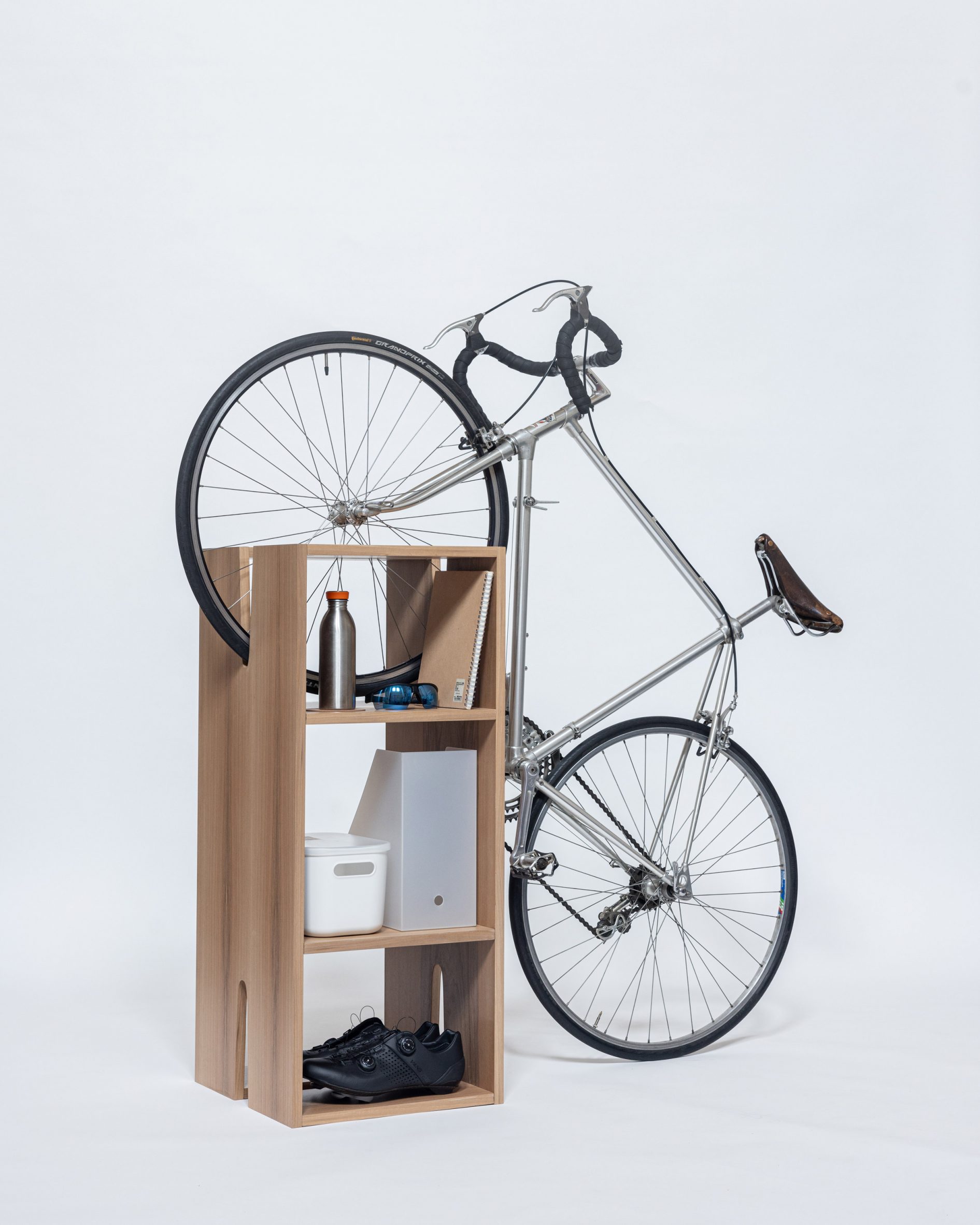 A wooden book shelf with a slot for keeping a bike in