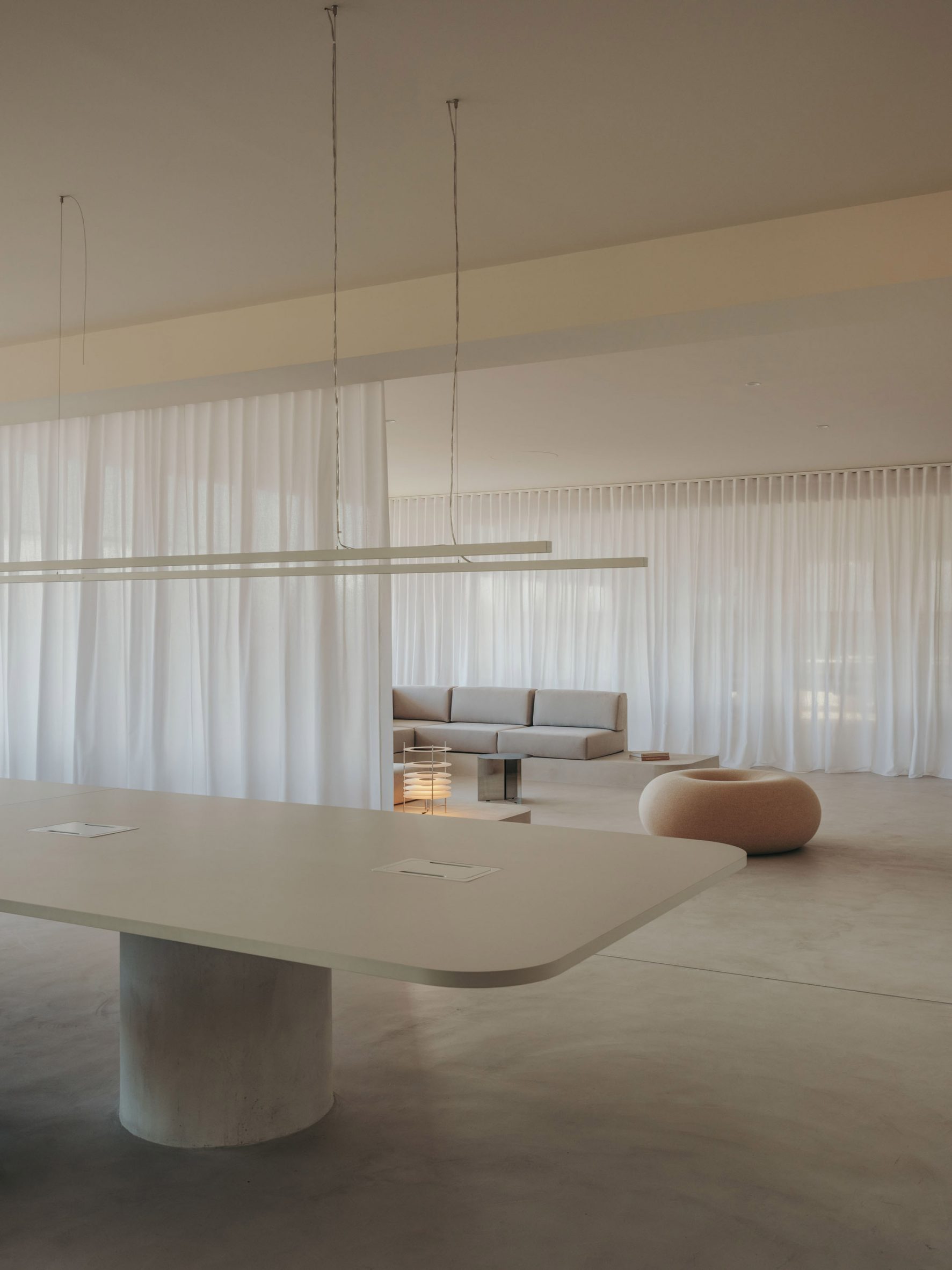 Table and lounge area inside office in Spain by Isern Serra