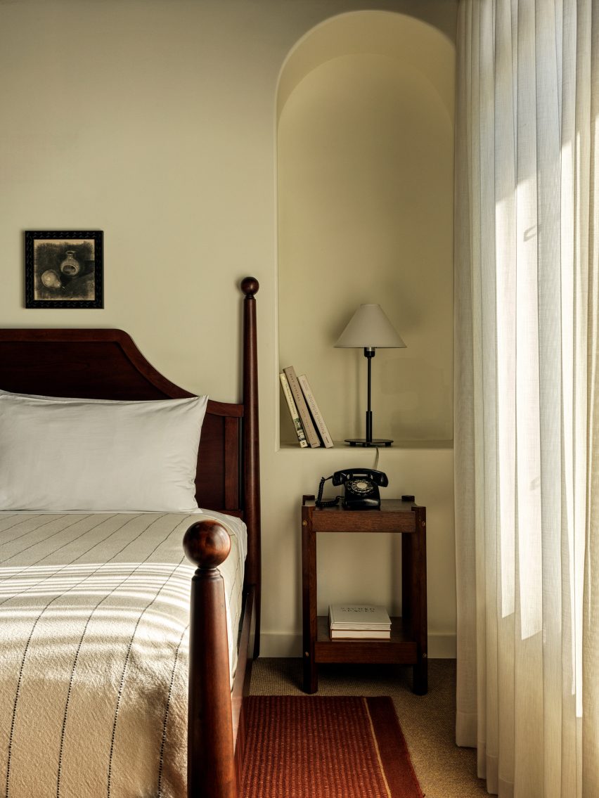 اتاق خواب با مبلمان چوب تیره و دیوارها و منسوجات با رنگ روشن تر
