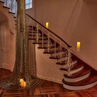A staircase with metallic hanging art