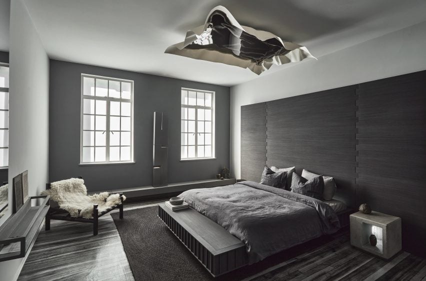 Gray bedroom with sculpture on ceiling