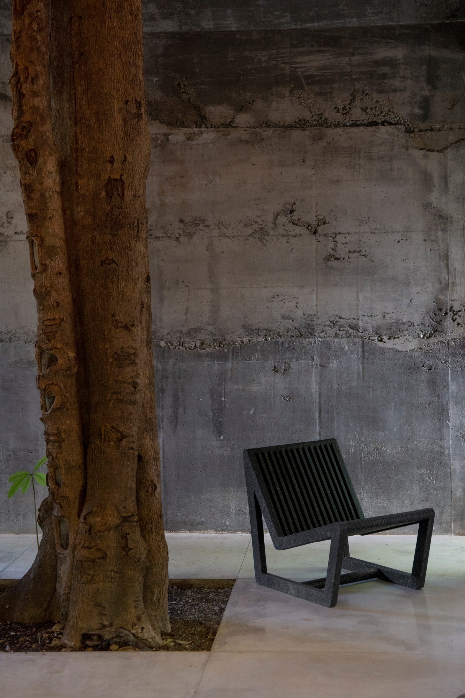 Black chair by Sungai Design next to a tree