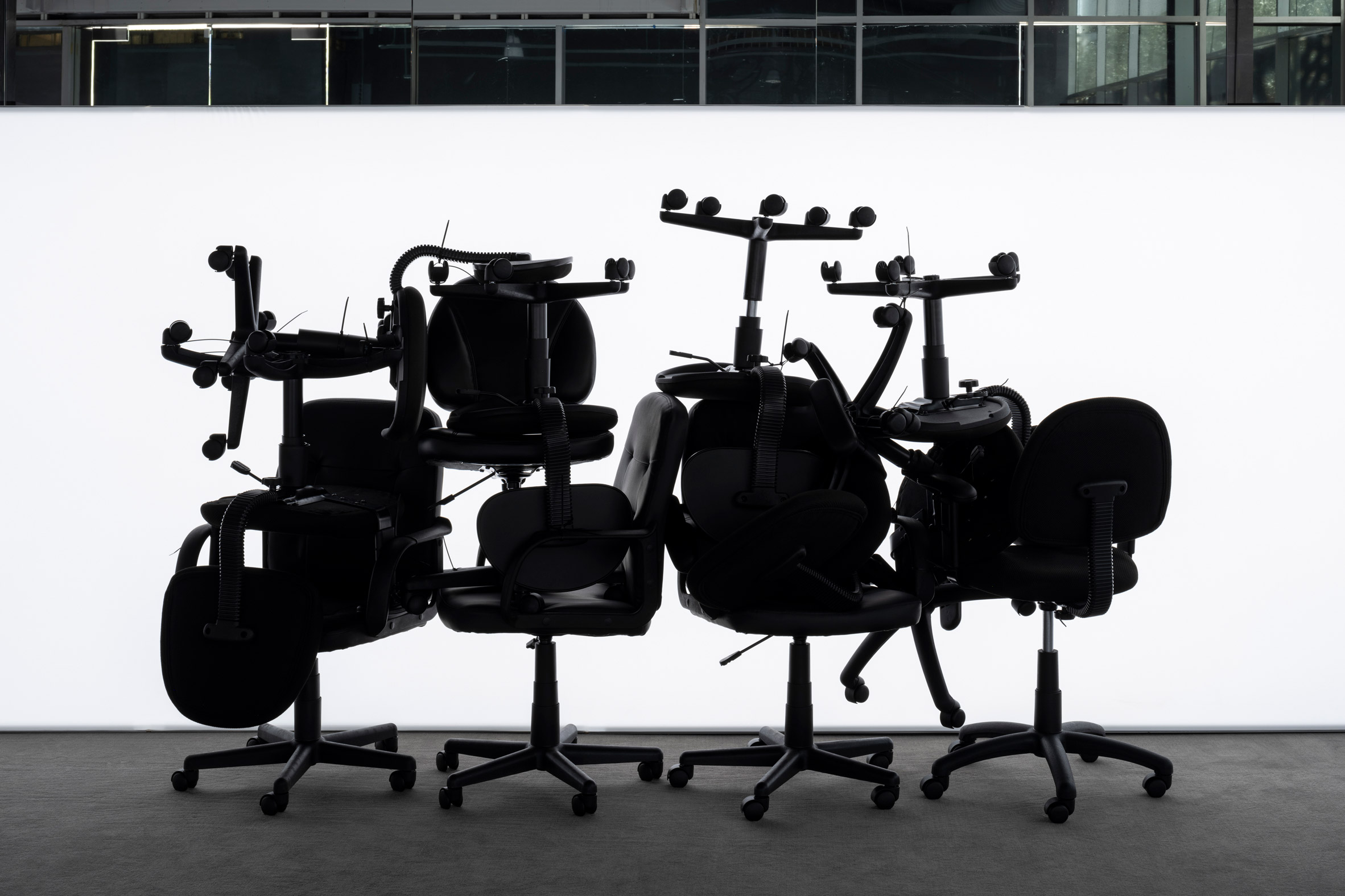 Pile of office chairs silhouetted against a bright light box