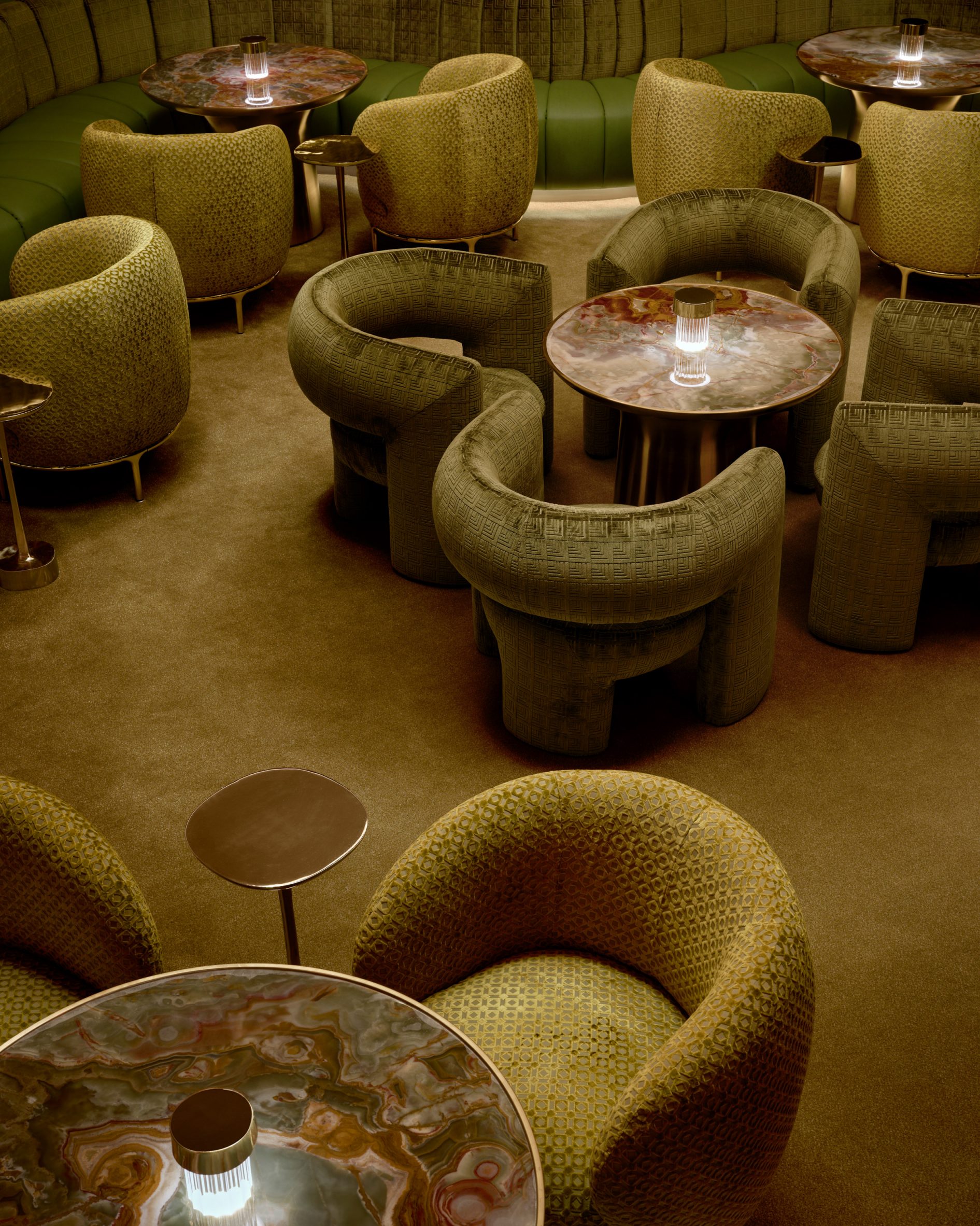 Conversation pit with carpet, chairs and banquettes in various shades of green