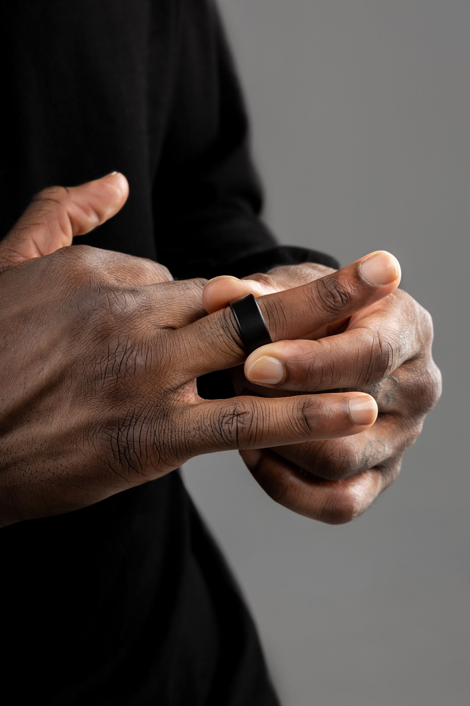 Close-up photo of a man's hands while he lifts a ring from his finger