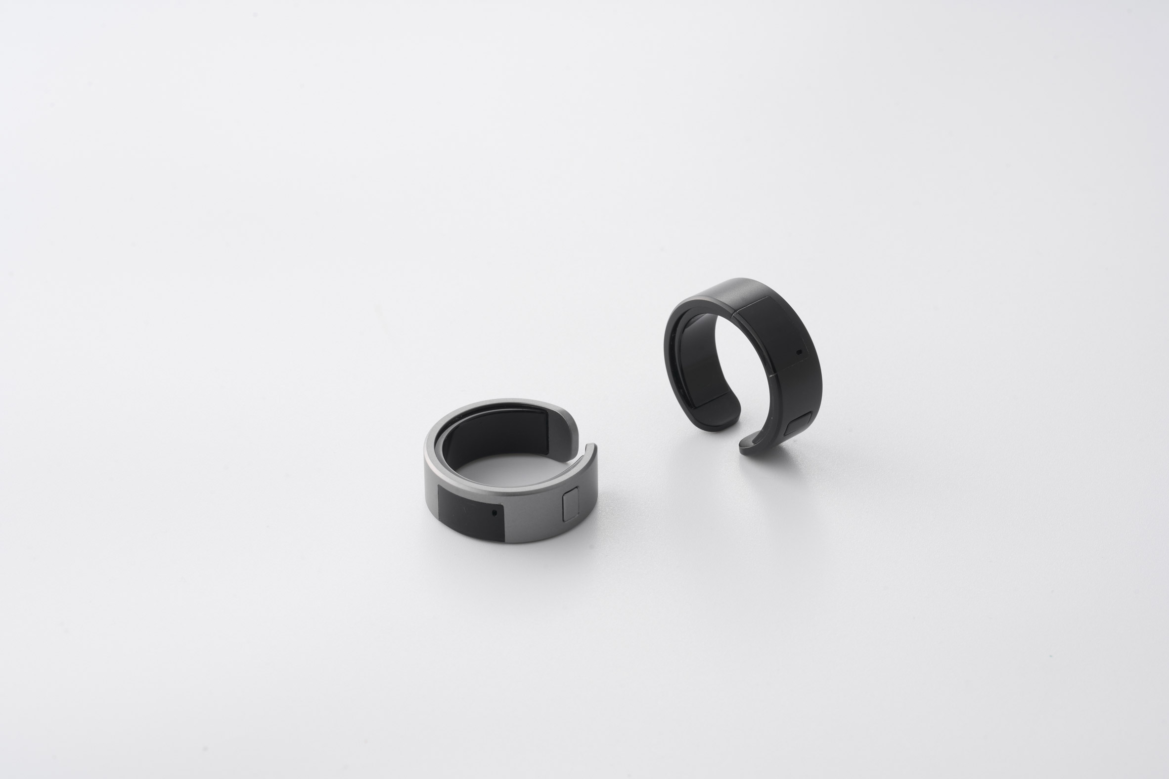 Photo of two WIZPR smart rings on a white surface, one silver one black