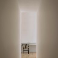 White hallway with wish bone chair at end