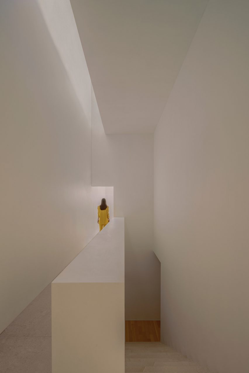 A person in white walking down a hallway