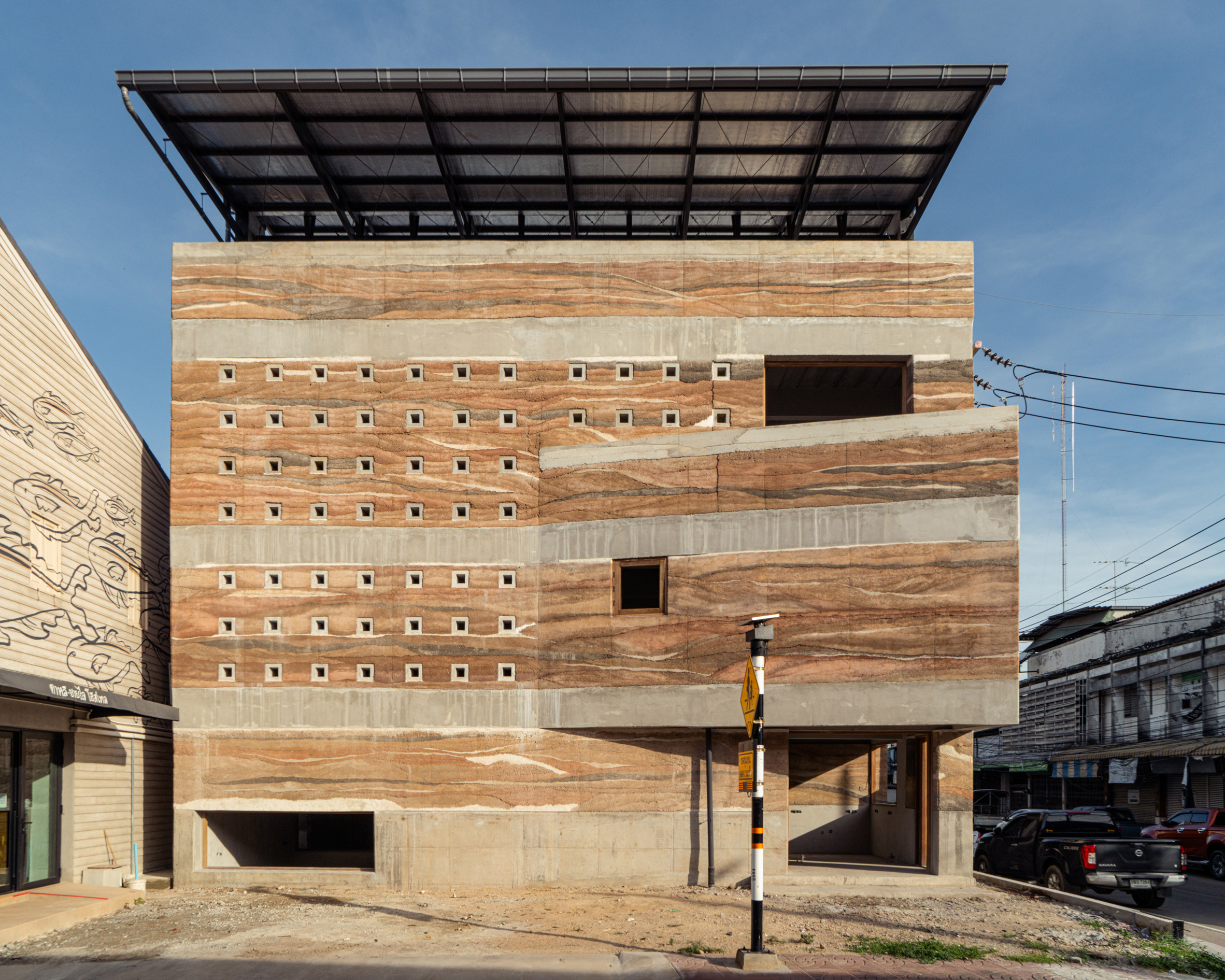 Exterior facade of rammed-earth building by Suphasidh Architects