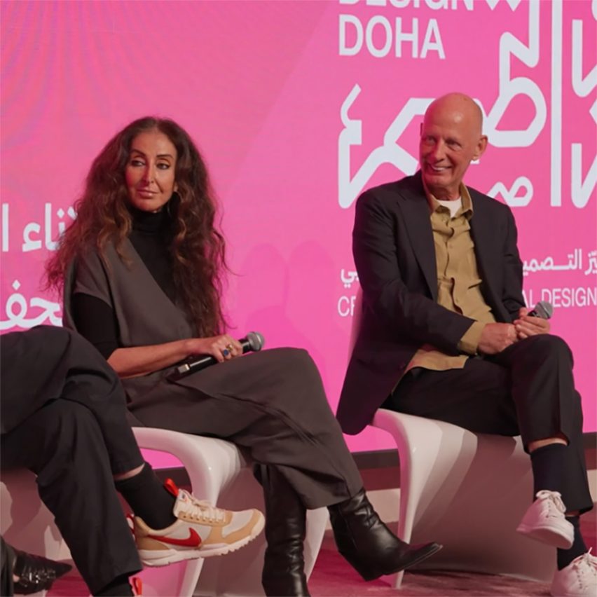 Video still of Manuela Lucà-Dazio and Ben van Berkel sitting on stage at a panel at the Design Doha Forum with a bright pink screen behind them