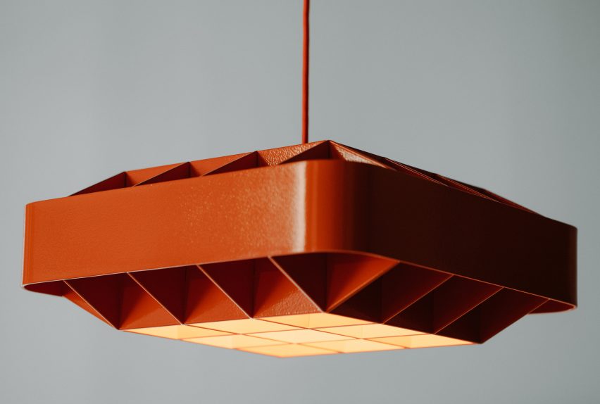 A red metal lamp designed by D'Armes
