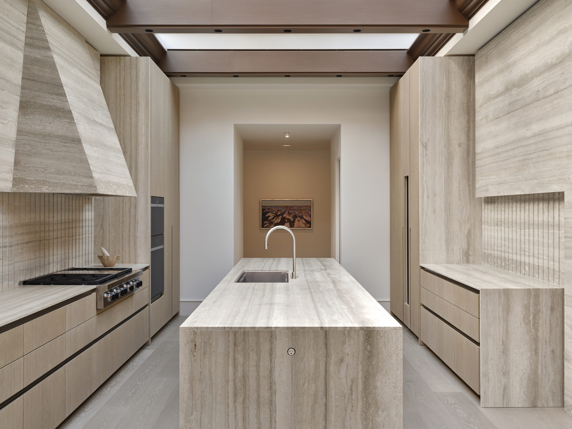Travertine kitchen with a long island in the centre