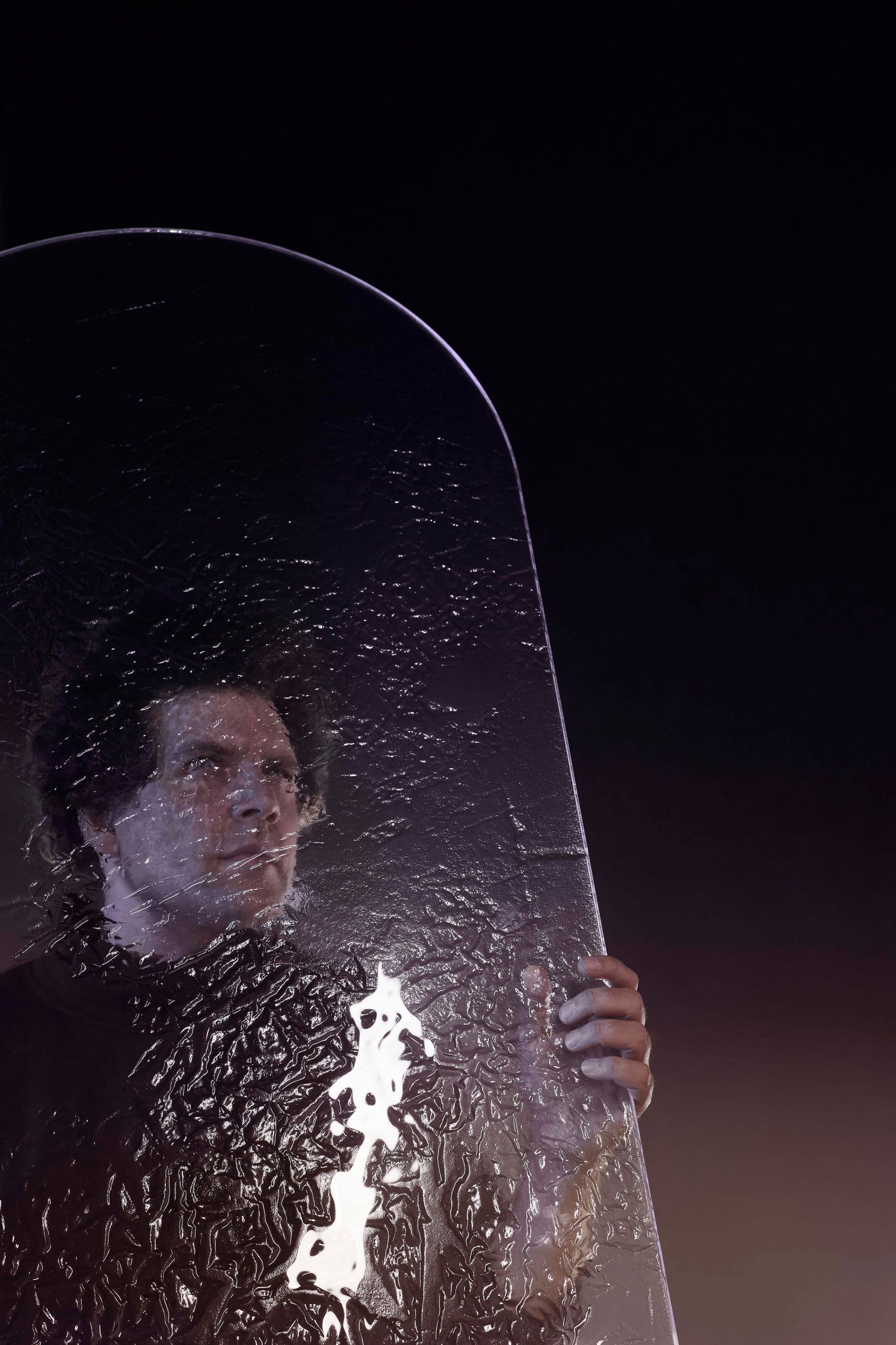 Maxim Velcovsky holding large fused-glass panel with a textured finish 