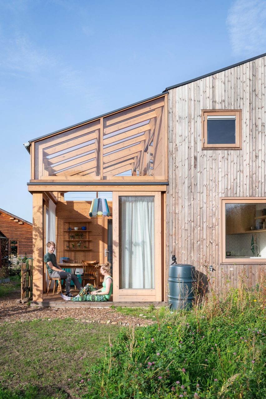 Casa de madera con volumen similar a un invernadero.
