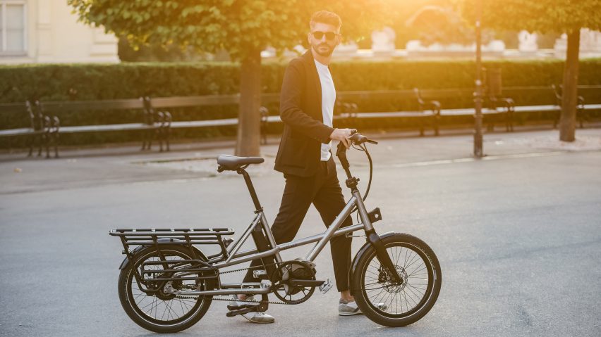a man walking with a bike of modern design