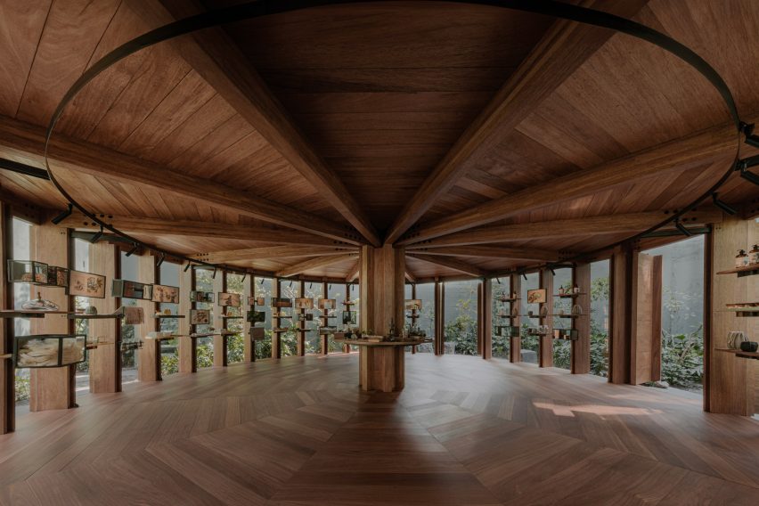 Interior del pabellón con techo y suelo de madera.