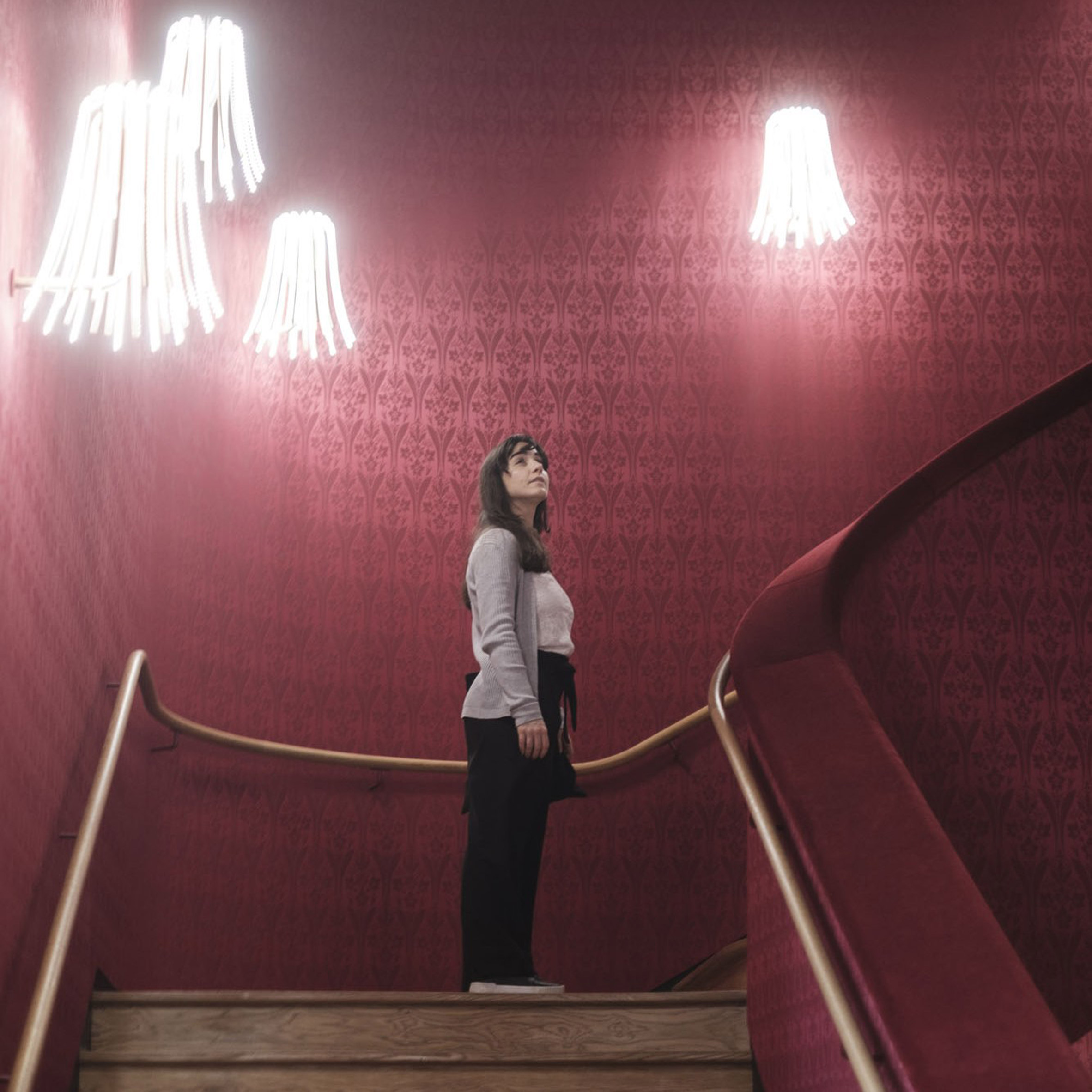 a photograph of a person standing at the top of a staircase