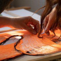 Photo of hands working on textiles