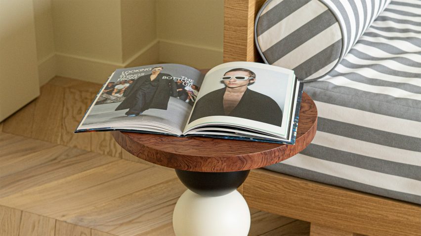 Photo of book on a side table in front of a stripe sofa