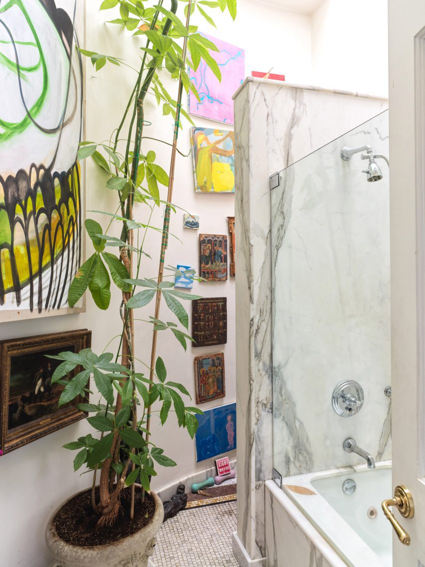 Bathroom with large plant and paintings on the wall