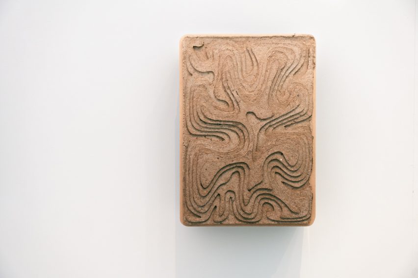 Wall-mounted charging point covered in recycled cardboard decorated with topographical lines